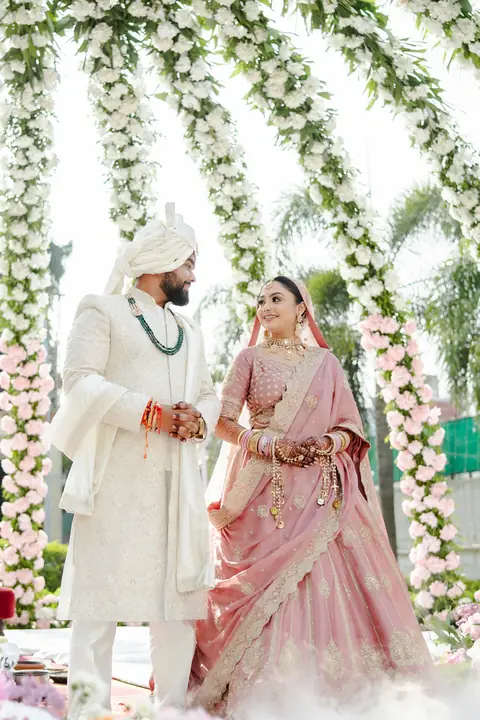 A couple beneath a flower mandap