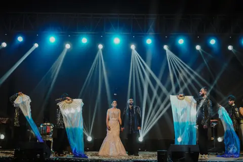 The couple on stage at the sangeet under stage lights
